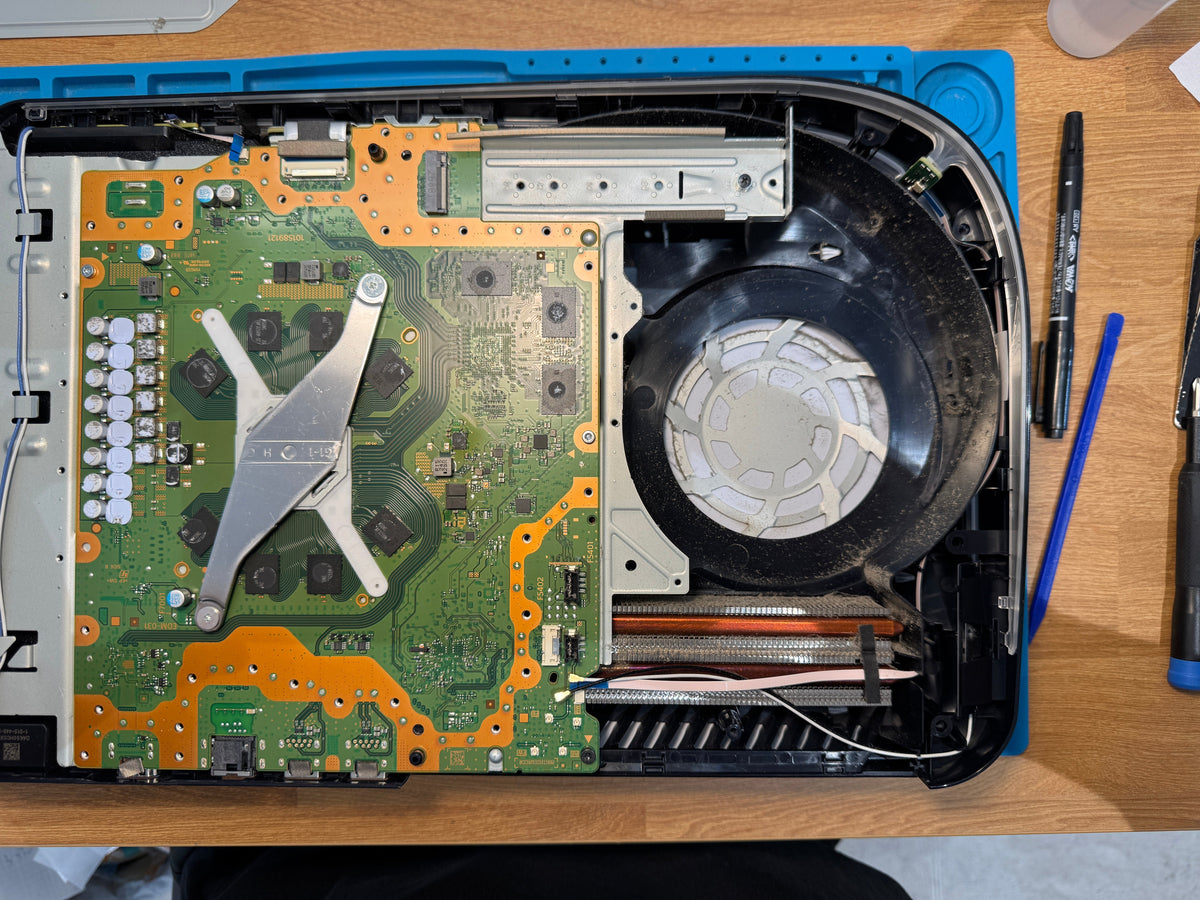 Real opened PS5 showing fan tunnel and dust during overheating repair